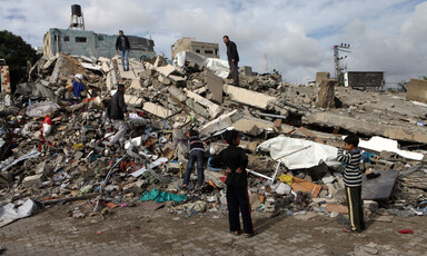 Children gather on rubble of building hit in Israeli air strike