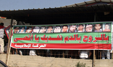 Arabic-language banner features the portraits of 13 males shot by Israeli police