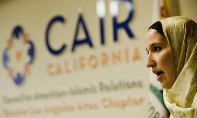 Woman stands in front of Council on American-Islamic Relations sign