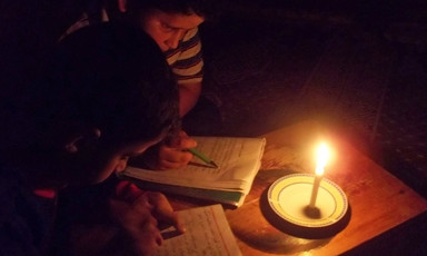 Boys read by candle light