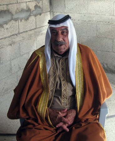 Candid portrait of older man wearing long robes and traditional headdress