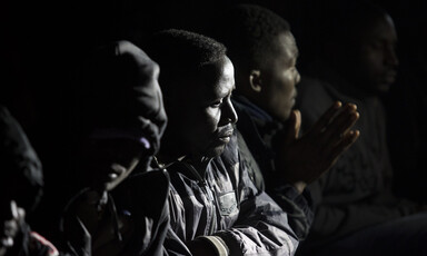 Close-up of men wearing winter coats sitting at night