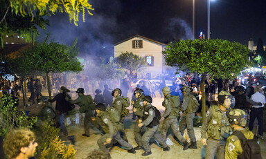 Riot gear police wearing army type uniforms chase demonstrators