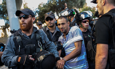 Israeli forces in riot gear arrest young man with blood smeared on his mouth