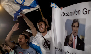 Young people wave Israeli flags during nighttime rally