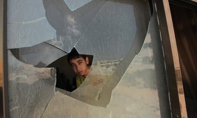 Boy peers through broken window
