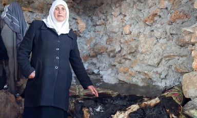 Woman stands in burned-out room