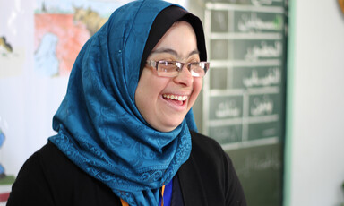 Close-up of smiling woman standing at front of classroom