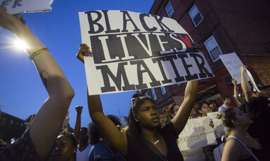 Woman holds sign reading Black Lives Matter during demonstration