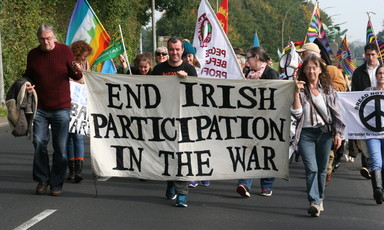 People march while carrying banner reading End Irish Participation In The War