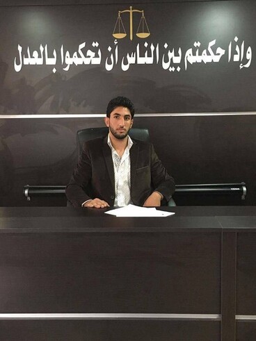 Young man wearing blazer sits at law college desk