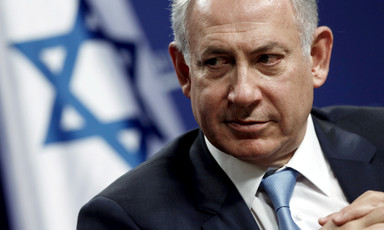 Close-up of Netanyahu with Israeli flag behind him
