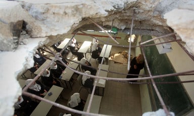 Aerial view of a classroom with a hole in the roof and in one of the walls