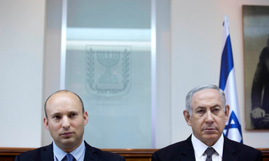 Naftali Bennett and Benjamin Netanyahu stand shoulder-to-shoulder in front of Israeli flag