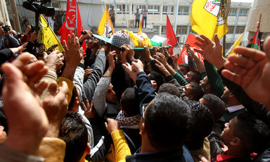 Photo shows hands reaching towards Murad Abu Ghazi as his body is carried during his funeral procession