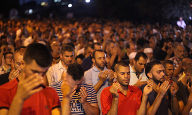 Hundreds of men pray outside at night