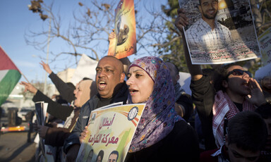 Young woman holds a poster in a crowd of protesters