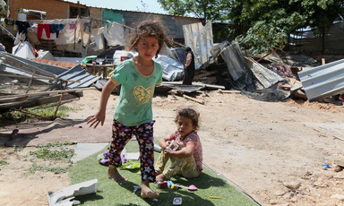 Two girls playing past the debris of homes after Israeli forces demolished them in Khan al-Ahmar. 