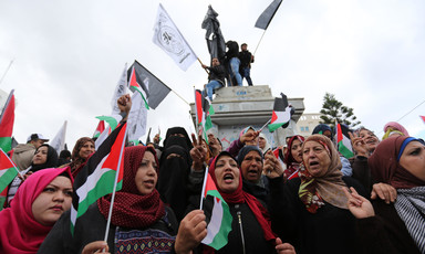 Crowd of women holding Palestinian flags and signs