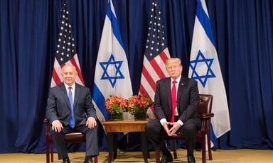 Photo shows Benjamin Netanyahu and Donald Trump sitting in front of American and Israeli flags