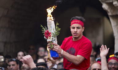 Palestinian Christian worshiper carrying a flame among the crowd. 