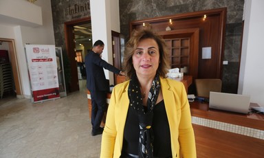 Mona Adnan Ghalayini stands in front of reception desk
