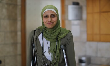 Dareen Tatour stands in court on crutches. 