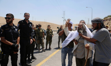 A Palestinian man faces Israeli forces.