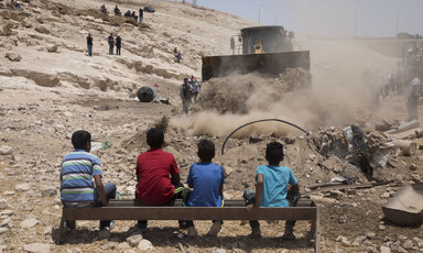 Palestinian children watching an Israeli bulldozer