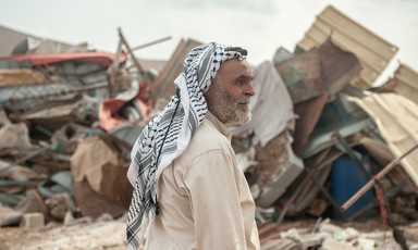 Omar Arif Bisharat stands in front of the rubble of his home in al-Hadidiya.