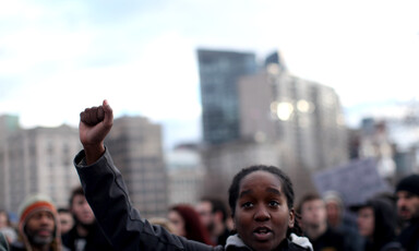 Black person raises fist in air during protest