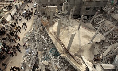 Birds-eye-view of people standing next to the rubble of a mosque
