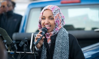 Representative Ilhan Omar speaks into a microphone. 