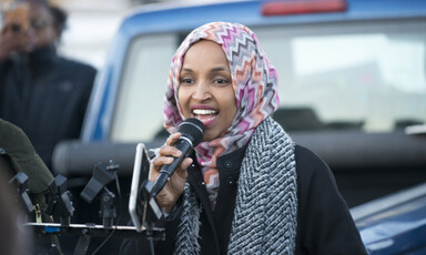 Representative Ilhan Omar speaks into a microphone.