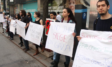 About six people stand with signs calling to end Israeli violence against Palestinians