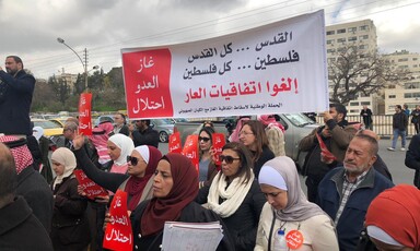 Protesters hold up banners on the street.