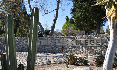 A rock wall displays the name of Pitzer College