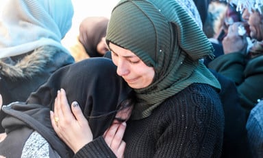 Woman cries on the shoulder of a young woman amid crowd