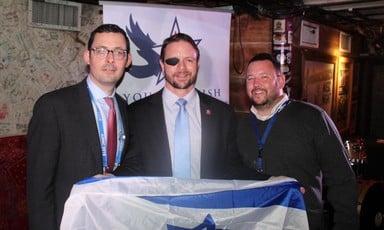 Three men holding an Israeli flag