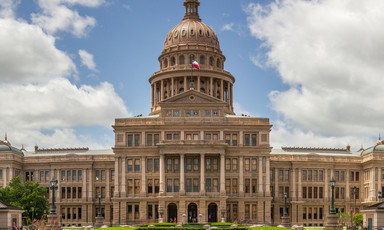 The Texas state capitol building with blue sky and clouds