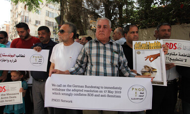 People stand together holding protest signs