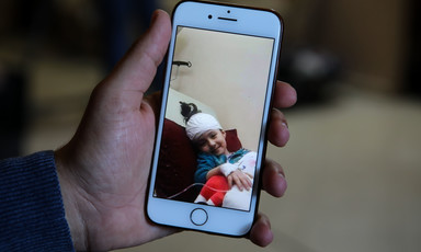 A picture on a mobile phone shows a bandaged girl smiling