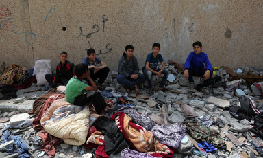 Six boys surrounded by rubble and damaged belongings