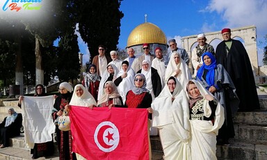 People hold the Tunisian flag near the Dome of the Rock.