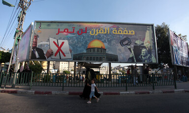 People walk past a huge billboard. 