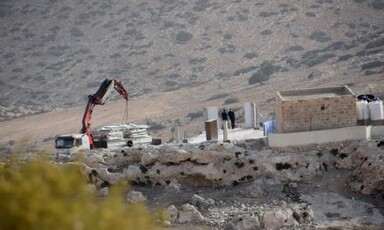 Contruction equipment loads parts of a prefab building