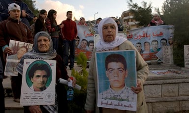 People hold posters and banners in cemetery