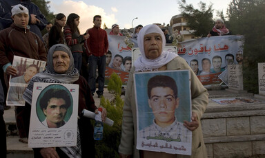 People hold posters and banners in cemetery