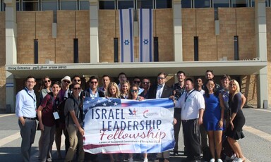 People holding banner pose for large-group photo