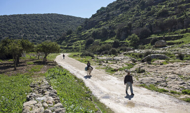 A man and child on a road between mountains